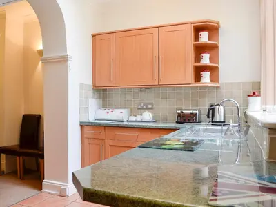 a kitchen with wooden cabinets and a counter top at Green Ghyll in Keswick