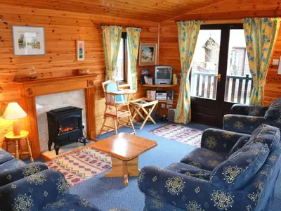 a living room with blue couches and a fireplace at Glenmore Lodge in Keswick