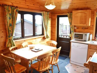 a kitchen and dining room with a table and chairs at Glenmore Lodge in Keswick
