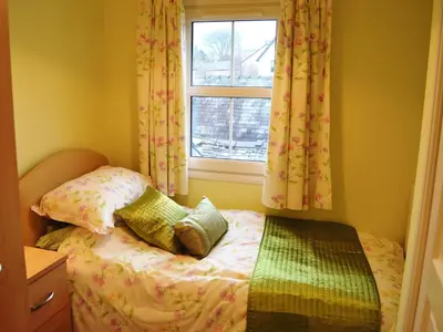a small bedroom with a bed and a window at Uncle's Cottage in Keswick