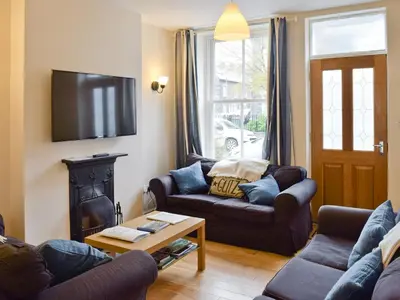 a living room with two couches and a tv at Falcon Crag in Keswick