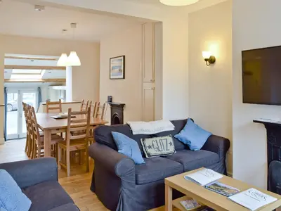 a living room with two couches and a dining room at Falcon Crag in Keswick