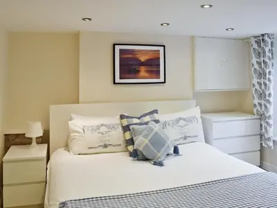a bedroom with a white bed with blue and white pillows at Falcon Crag in Keswick