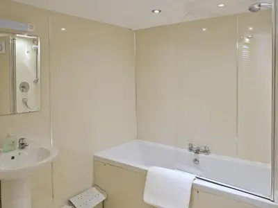 a white bathroom with a sink and a mirror at Falcon Crag in Keswick