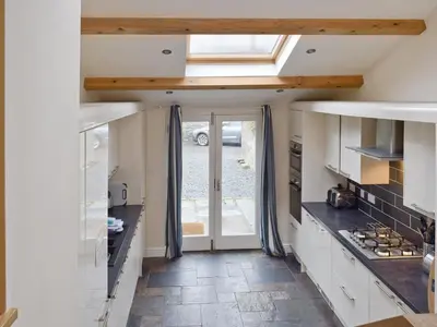 a kitchen with a vaulted ceiling with a skylight at Falcon Crag in Keswick