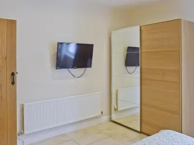a bedroom with a mirror and a tv on the wall at Falcon Crag in Keswick