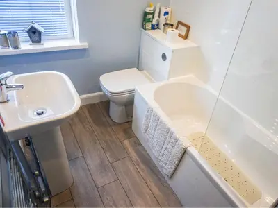 a bathroom with a white toilet and a sink at Valentine Cottage in Keswick