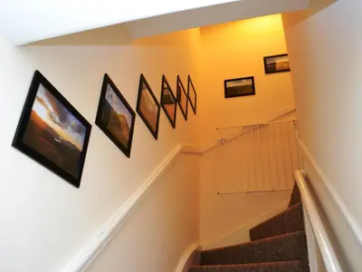 a staircase with framed pictures on the wall at Riverbank in Keswick