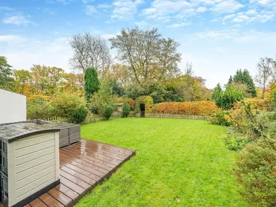a garden with a wooden deck and a lawn at Barleycorn in Keswick