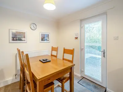 a dining room with a wooden table and chairs at Barleycorn in Keswick