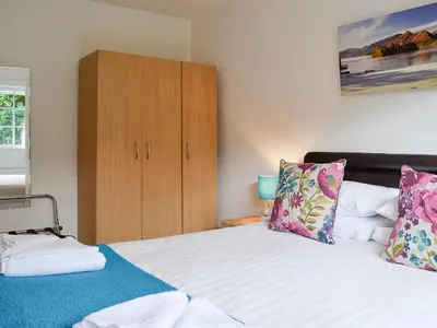 a bedroom with two beds and a wooden cabinet at Haystacks in Keswick