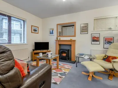 a living room with a couch and a fireplace at Chaucer Lodge Apt 1 in Keswick