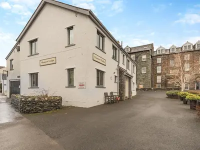 a white building with street signs on the side of it at Chaucer Lodge Apt 1 in Keswick