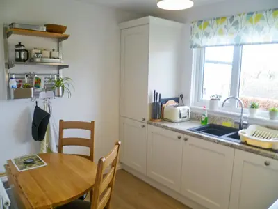 a kitchen with a table and a sink and a table at The Bolthole Formerly Candlemas in Keswick