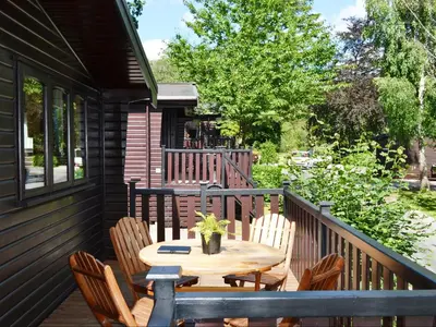 a wooden deck with a table and chairs at Fern Lodge- Burnside Park in Keswick