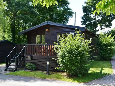 a small cabin with a porch and a deck at Fern Lodge- Burnside Park in Keswick