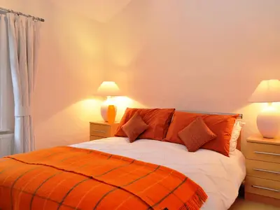 a bedroom with a bed with two night stands and two lamps at 4 The Plosh in Keswick