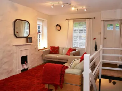 a living room with a couch and a fireplace at 4 The Plosh in Keswick