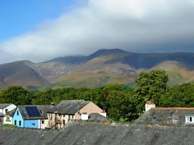 a group of houses with mountains in the background at Catbells Cottage Keswick in Keswick