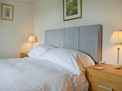 a bedroom with a large white bed with two lamps at Manesty in Applethwaite