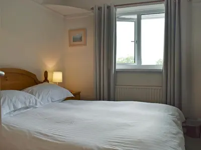 a bedroom with a white bed and a window at Manesty in Applethwaite