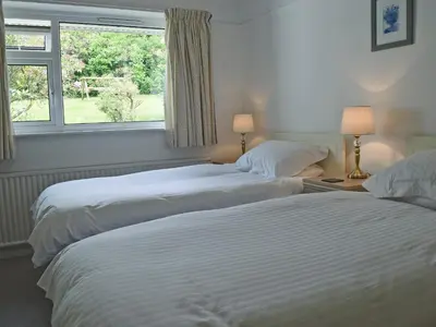 two beds in a room with a window at Manesty in Applethwaite