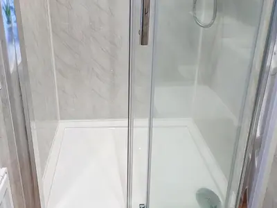 a shower with a glass door in a bathroom at 1 Tower Cottage in Portinscale