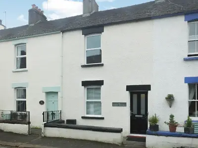 a white house with a black door and windows at Causey Cottage in Keswick