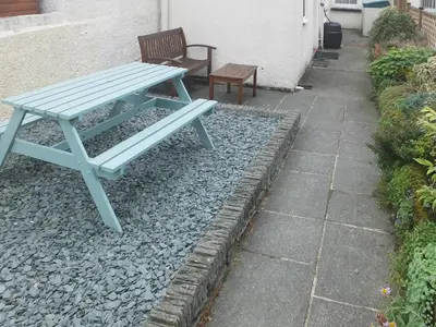 a blue picnic table and a bench sitting on rocks at Causey Cottage in Keswick