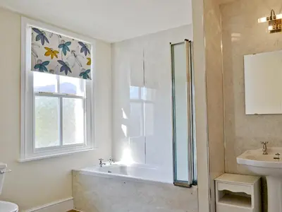 a bathroom with a tub and a sink and a window at 14 Greta Villas in Keswick