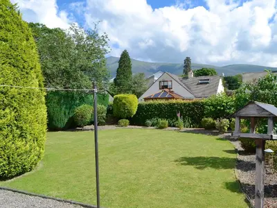 a yard with a fence and a house at Polperro in Keswick