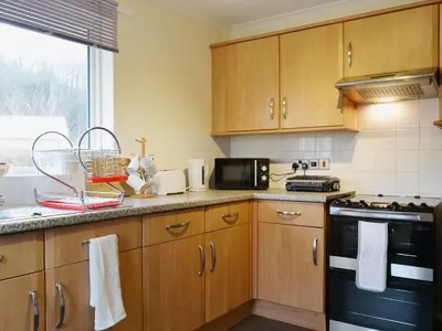 a kitchen with wooden cabinets and a black appliance at La'al Gem in Keswick