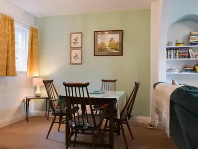 a dining room with a table and four chairs at Poachers Cottage in Keswick