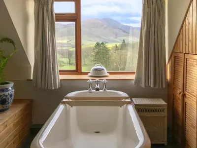 a bath tub in a bathroom with a window at Overwater Lodge in Bassenthwaite Lake