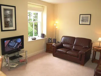 a living room with a brown leather couch and a television at Bishop View in Braithwaite