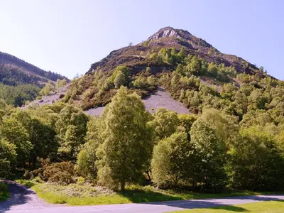 a mountain with trees in front of a road at Bishop View in Braithwaite