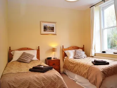 a bedroom with two beds next to a window at Bishop View in Braithwaite