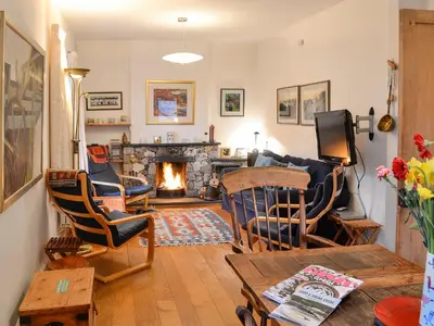 a living room with a couch and a fireplace at The Larches in Braithwaite