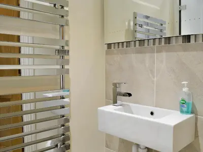 a bathroom with a white sink and a mirror at The Larches in Braithwaite