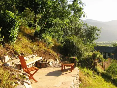 two wooden benches sitting on a stone walkway at The Larches in Braithwaite