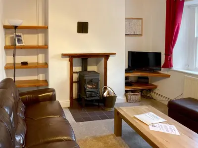 a living room with a couch and a fireplace at Croft Cottage in Braithwaite