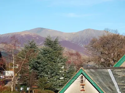 a view of a house with mountains in the background at Croft Cottage in Braithwaite