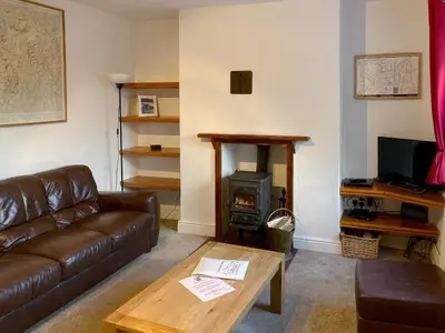 a living room with a couch and a wood stove at Croft Cottage in Braithwaite