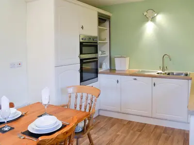 a kitchen with a wooden table and a sink at Beech End in Braithwaite
