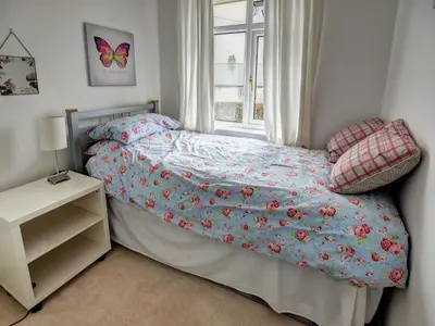a small bedroom with a bed with a window at Roseworth in Portinscale