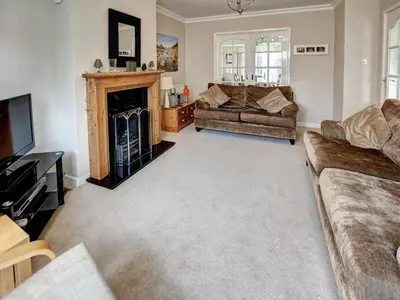a living room with two couches and a fireplace at Roseworth in Portinscale
