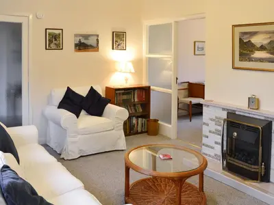 a living room with a white couch and a fireplace at Whitegates in Portinscale