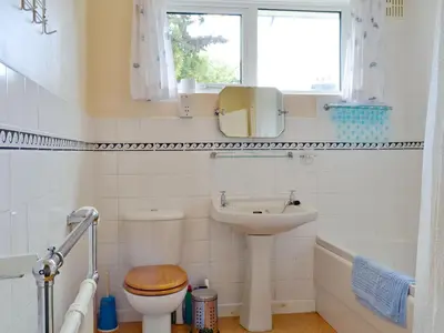 a bathroom with a sink and a toilet and a window at Whitegates in Portinscale
