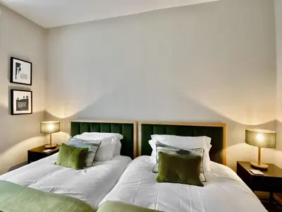 two beds with green and white pillows in a room at 2 Harney Peak in Portinscale