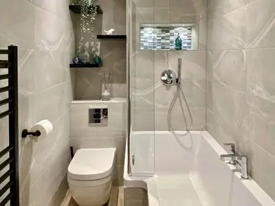 a bathroom with a shower and a toilet and a tub at 2 Harney Peak in Portinscale